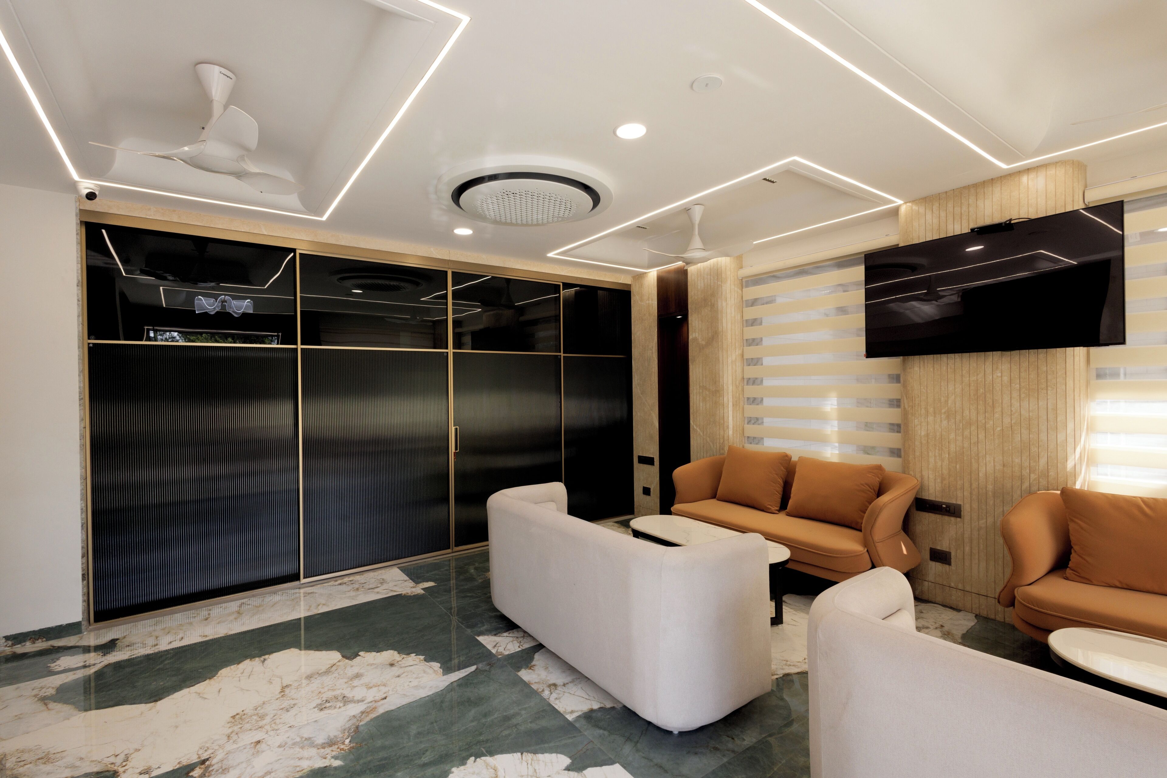 A modern living room with a sofa, a coffee table, and a flat-screen TV mounted on the wall.