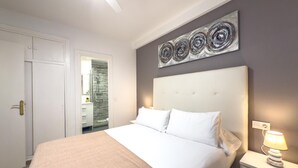 A bedroom with a bed, bedside table, and a wall-mounted artwork. - Central Apartment with Balcony in Estepona (Estepona)