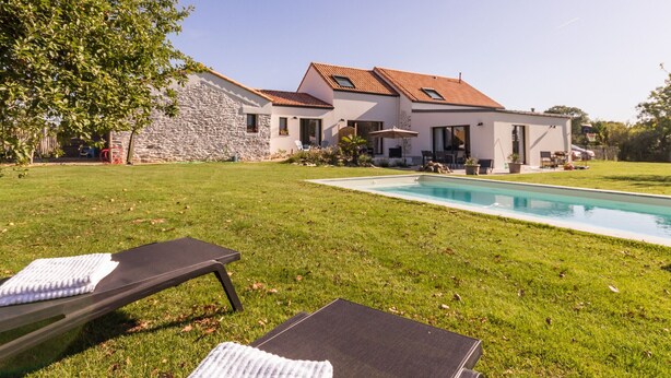 A modern house with a swimming pool, stone wall, and a well-maintained lawn. - Jungle Studio with Terrace and Heated Pool near Nantes (Port-Saint-Père)