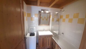 A compact bathroom with a sink, mirror, and shower.