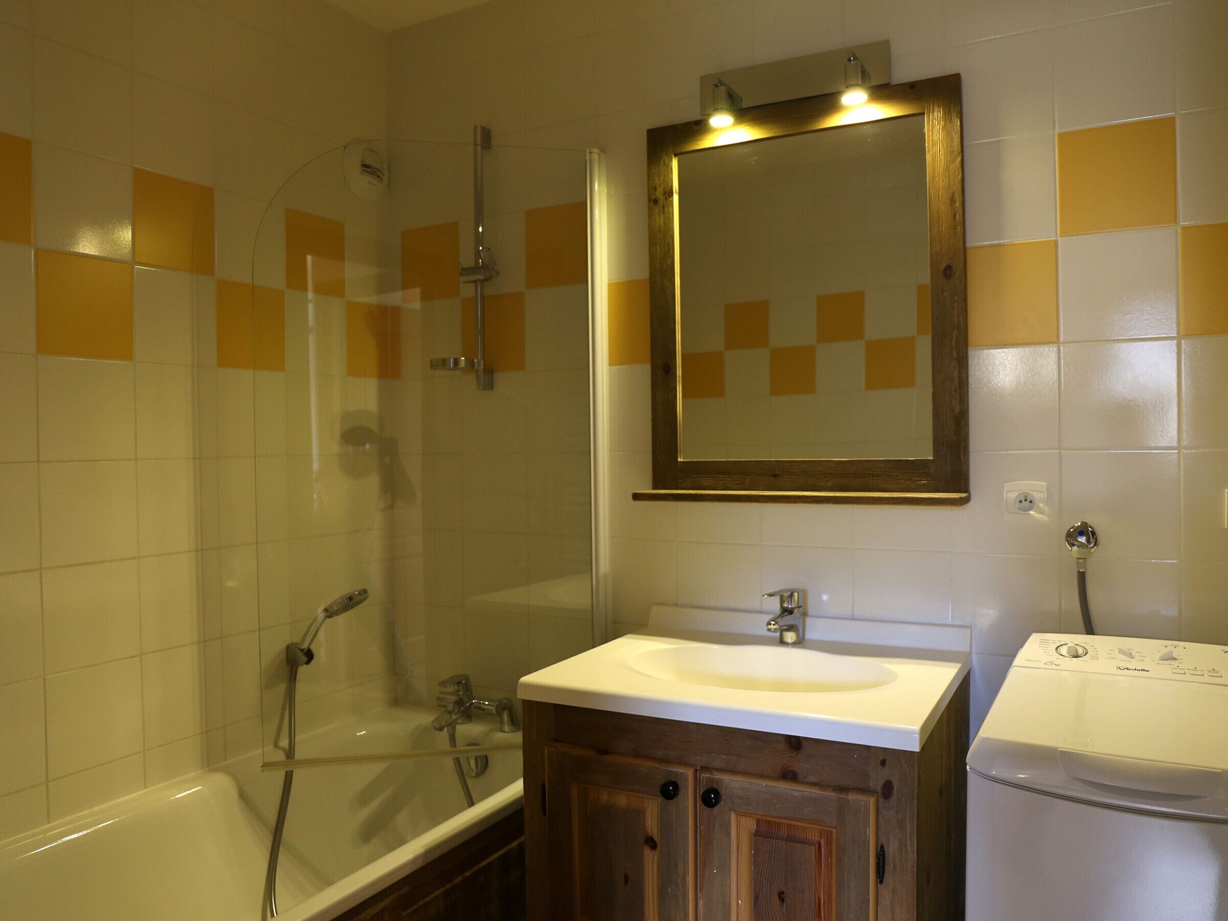 A bathroom with a bathtub, a shower, a sink, and a mirror.