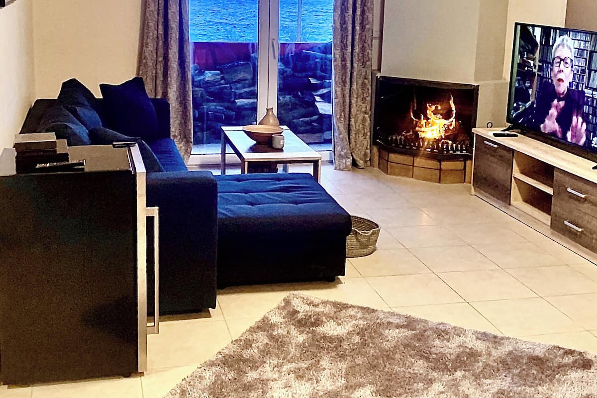 Apartamento Deluxe, vistas al mar | Zona de estar | Smart TV de 45 pulgadas con canales por satélite