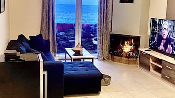 Apartament Deluxe, vistes al mar | Sala d'estar | Televisor intel·ligent de 45 polzades amb canals per satèl·lit