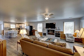 Relax in this cozy living space with a large flat-screen TV, comfortable sofa, and kitchenette.