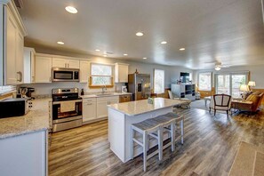 Enjoy cooking in this well-equipped kitchen with a central island, microwave, oven, and sink.