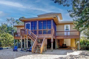 Une maison en bois à deux étages, dotée d’un balcon et d’une véranda couverte.