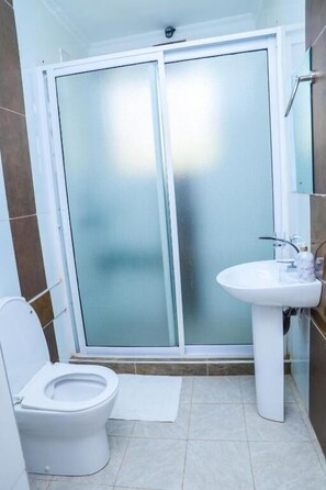 Een douche, pantoffels, handdoeken, zeep