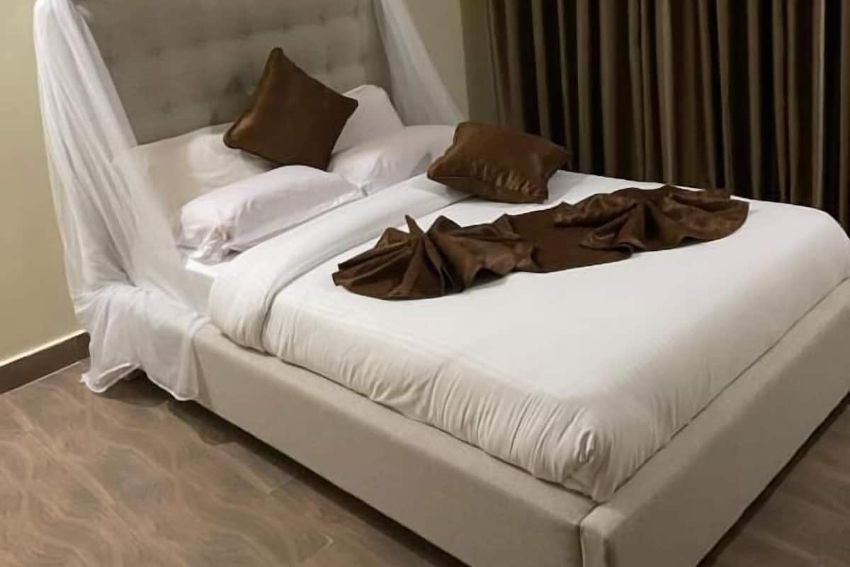 Una cama con dosel, almohadas y una manta.