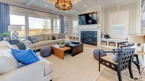 A spacious living room with a large sofa, a coffee table, and a fireplace. - Spacious 4BR Retreat Near Bozeman (Belgrade)