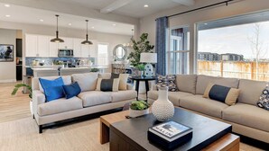 A spacious living room with a beige sofa, a coffee table, and a view of the outside. - Spacious 4BR Retreat Near Bozeman (Belgrade)