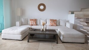 A modern living room with a sectional sofa, a coffee table, and a decorative wall piece.
