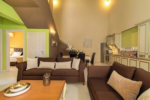 A modern living room with a brown sofa set, a wooden coffee table, and a dining area with a white table and chairs.