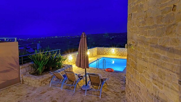 A stone patio with a pool, lounge chairs, and an umbrella. - Amoena Villa - Theo Villas With Sea View (Marathokefala)