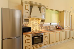 A modern kitchen with a stainless steel refrigerator, a built-in oven, and a microwave.