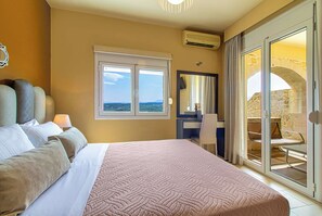 Een hotelkamer met een bed, een bureau, een stoel en een balkon met een stenen muur.
