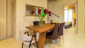 Un coin repas avec une table en bois, quatre chaises et un vase rempli de fleurs.