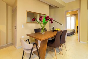 Un coin repas avec une table en bois, quatre chaises et un vase rempli de fleurs.