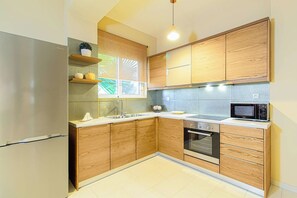 Une cuisine avec des meubles en bois, un réfrigérateur en acier inoxydable, un four à micro-ondes et un évier.