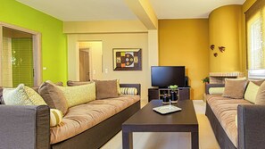 Un salon moderne avec deux canapés, une table basse et un téléviseur à écran plat.