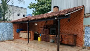 Un patio de ladrillo con suelo de baldosas, un banco de madera y una pequeña mesa.