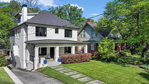A two-story house with a front porch, a chimney, and a well-maintained lawn. - Le Venture (Atlanta)