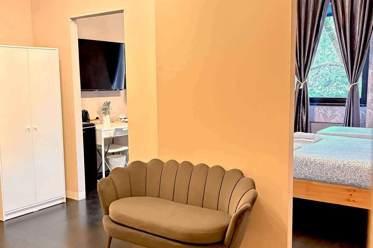 A modern room with a sofa, a bed, and a desk.