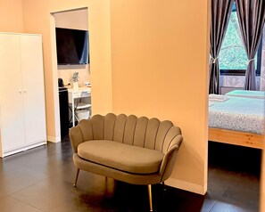 Una habitación moderna con sofá, cama y escritorio.