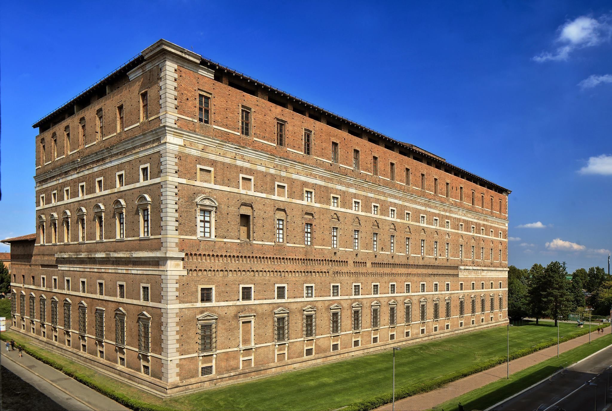 A large, multi-story brick building with a symmetrical facade, large windows, and a flat roof.