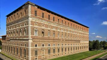 A large, multi-story brick building with a symmetrical facade, large windows, and a flat roof.