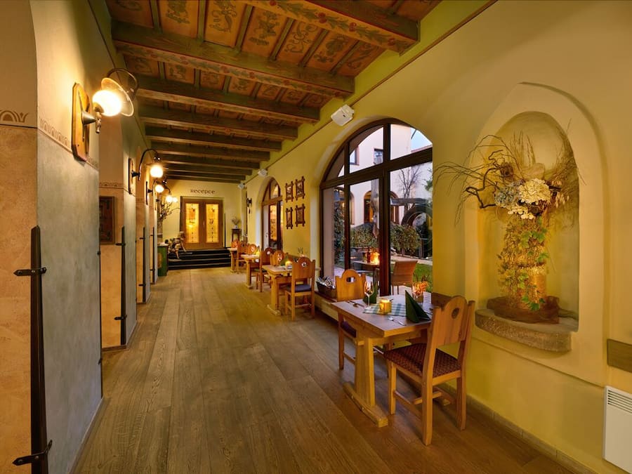 A corridor with wooden flooring and a reception desk at the end.