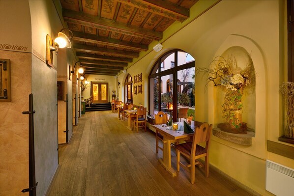 A corridor with wooden flooring and a reception desk at the end.
