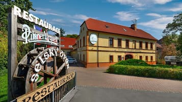 Un edificio tradizionale con un cartello che indica 'Pilsner Urquell' e 'Hotel Sejsky ovnice'.