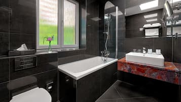 A modern bathroom with a bathtub, a shower, and a sink.