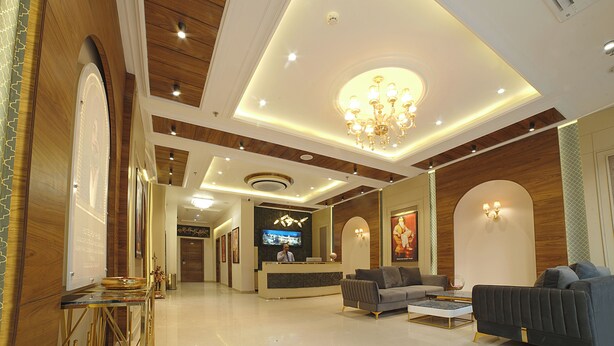 A hotel lobby with a reception desk, seating area, and a chandelier. - PSK Pride by BDS Hotels (Amritsar)