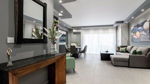 Una sala moderna con comedor, un espejo grande y un sofá.