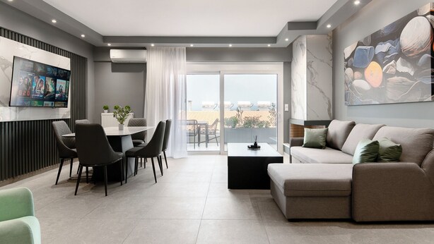 Una sala de estar moderna con comedor, un sofá y un ventanal con vistas.