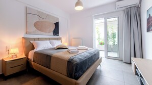 Un dormitorio moderno con cama, mesitas de noche, una lámpara colgante y vistas a través del ventanal.