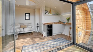 A modern kitchen with a wooden countertop, a built-in dishwasher, and a small dining area with a bench.
