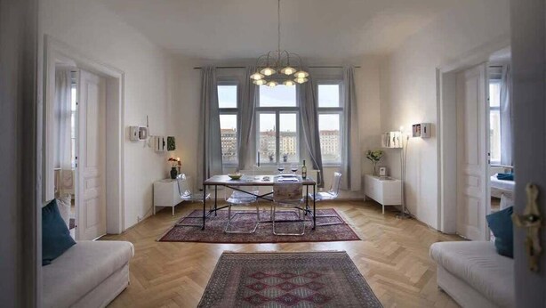 A spacious living room with a dining area, large windows, and a chandelier. - Waterfront Apt w/ River Views & Trendy Location (Praha 5)