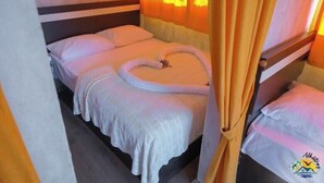 Een eenpersoonsbed met hemelbed, witte beddengoed en een logo op het hoofdeinde.