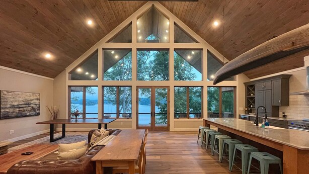 Una cocina amplia con una isla grande, taburetes de bar y vistas al exterior.