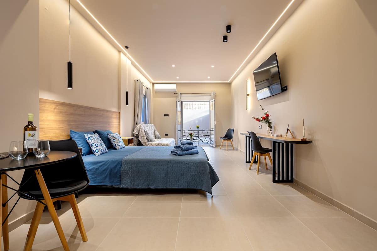 A modern hotel room with a bed, a desk, and a TV.