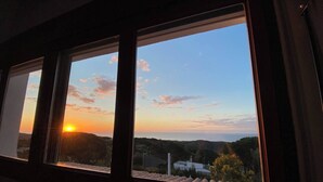 A view through a window at sunset with the sun setting behind a hill. - Intimate Family Villa with big private pool & panoramic sea view (CT)