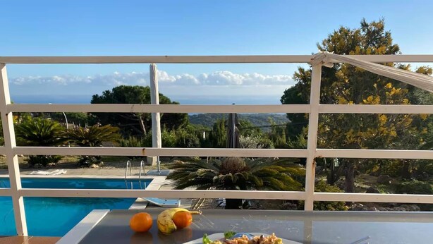 A dining table with a plate of food and a view of a swimming pool and landscape. - Intimate Family Villa with big private pool & panoramic sea view (CT)