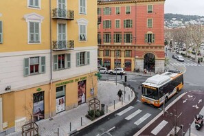 Vista de la calle con un edificio amarillo, uno rojo y un autobús.