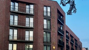 A multi-story hotel with a brick facade, large windows, and balconies.