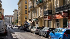 A street with parked cars and a building with balconies and a dome. - Nice duplex with patio (Niza)