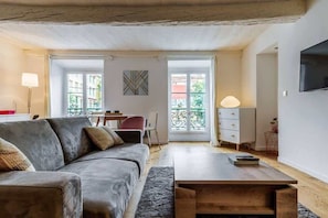 A modern living room with a sofa, a coffee table, a TV, and a balcony with a view. - Beautiful loft between Old Nice and the port (Niza)