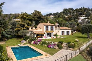 A large house with a swimming pool, surrounded by a well-maintained garden and a hilly landscape. - Magnificent villa with panoramic sea view (Niza)