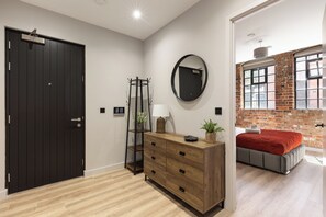 A bedroom with a bed, a dresser, a mirror, and a door.